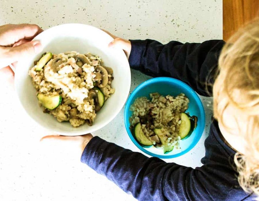 child holding risotto bowl