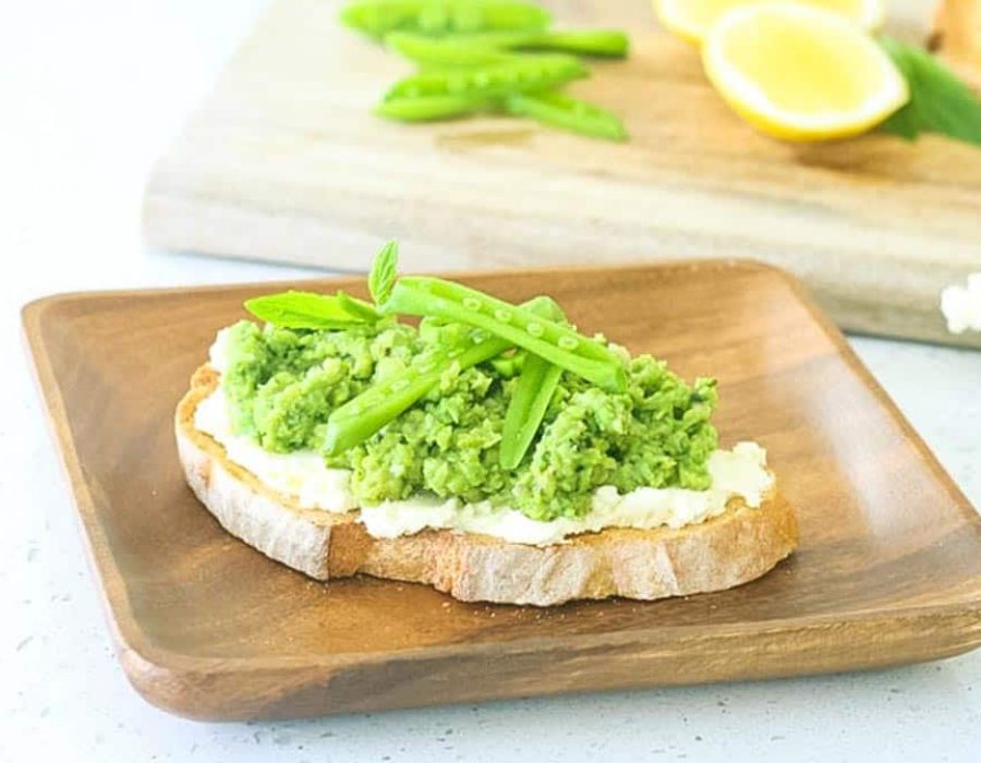 Pea and Fava Bean Crostini on a wooden plate