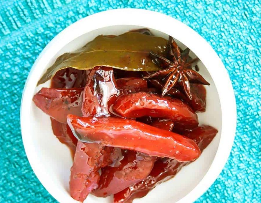a white bowl on a turquoise cloth filled with steamed quince slices
