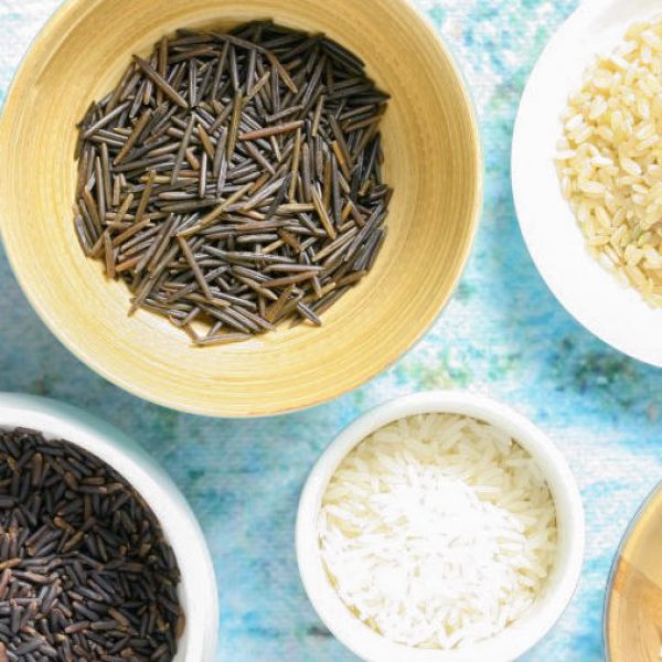 several varieties of uncooked rice in bowls