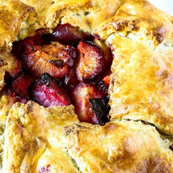 a close up of a golden and flaky tart with roasted plums