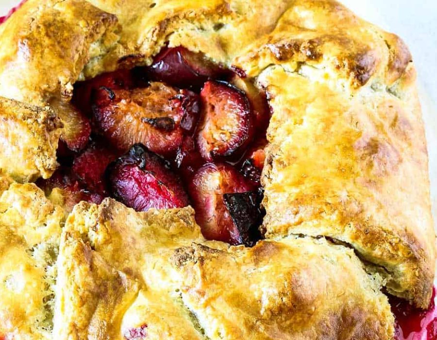 a close up of a golden and flaky tart with roasted plums