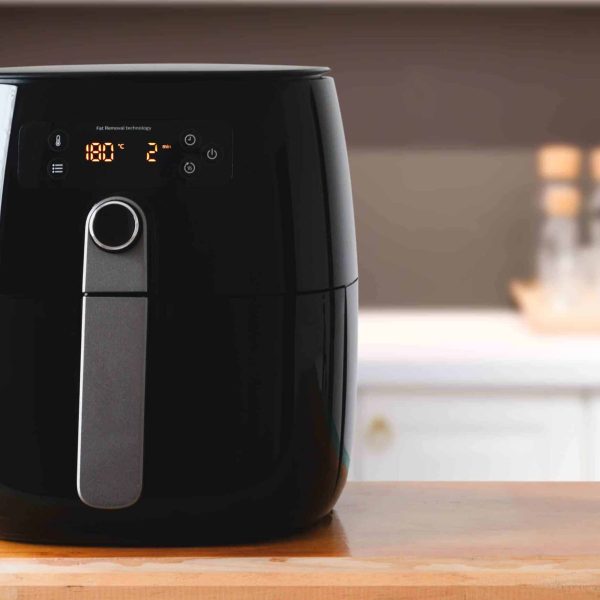 Air fryer machine cooking potato fried in kitchen.  Lifestyle of new normal cooking.